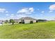 Exterior view of a home with a well-maintained lawn, a two-car garage, and a view of a serene pond at 9238 Sw 60Th Terrace Rd, Ocala, FL 34476