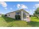 Rear exterior view of home featuring a screened sunroom and well-maintained lawn at 9238 Sw 60Th Terrace Rd, Ocala, FL 34476