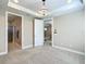 Spacious main bedroom featuring a decorative chandelier, neutral carpet, and doors leading to the main bathroom and sitting room at 9480 Sw 76Th St, Ocala, FL 34481