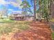 Exterior view of home with a screened-in porch in a spacious backyard with mature trees at 1022 Ne 11Th Ave, Ocala, FL 34470