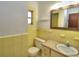 Yellow tiled bathroom with a window and a mirror above the sink at 1022 Ne 11Th Ave, Ocala, FL 34470