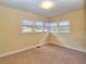 Sunlit bedroom with wall-to-wall carpet and three windows at 1022 Ne 11Th Ave, Ocala, FL 34470