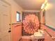 Cozy bathroom features pink tiles, a floral shower curtain, and essential fixtures at 1034 Ne 11Th St, Ocala, FL 34470