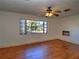 Bright bedroom with hardwood floors, a ceiling fan, a window, and an air conditioner at 1034 Ne 11Th St, Ocala, FL 34470