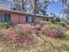 The side yard of the home is decorated with pink azaleas and green bushes at 1034 Ne 11Th St, Ocala, FL 34470
