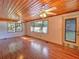 Spacious living area with wood-paneled ceiling, laminate flooring, natural light, and backyard access at 1034 Ne 11Th St, Ocala, FL 34470