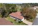 Aerial view of a charming home with red roof surrounded by lush greenery and a golf course at 11587 Sw 72Nd Cir, Ocala, FL 34476