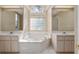Bathroom featuring an oval tub, double sinks, and natural light at 11587 Sw 72Nd Cir, Ocala, FL 34476