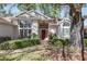Inviting home exterior featuring a red front door, large windows, and mature landscaping at 11587 Sw 72Nd Cir, Ocala, FL 34476