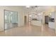 Open-concept living room with hardwood floors, a ceiling fan, and natural light from sliding glass doors to a sunroom at 11587 Sw 72Nd Cir, Ocala, FL 34476