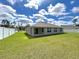 Spacious backyard featuring lush lawn, a covered patio, and white fence at 13042 Sw 60Th Court Rd, Ocala, FL 34473