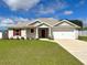 Charming single-story home with a well-manicured lawn and a two-car garage with red accents at 13042 Sw 60Th Court Rd, Ocala, FL 34473