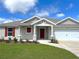 Welcoming home exterior with a manicured front yard and a red front door and shutters at 13042 Sw 60Th Court Rd, Ocala, FL 34473