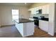 Modern kitchen featuring white cabinets, dark countertops, and stainless steel appliances at 13042 Sw 60Th Court Rd, Ocala, FL 34473