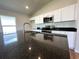 Kitchen island featuring modern sink fixtures and a sleek black countertop with a view at 13042 Sw 60Th Court Rd, Ocala, FL 34473