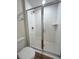Bathroom shower featuring white tiling, glass doors, and modern fixtures at 13042 Sw 60Th Court Rd, Ocala, FL 34473