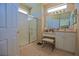 Bathroom featuring a glass-enclosed shower, vanity with a makeup counter, and neutral tile flooring at 13128 Se 97Th Terrace Rd, Summerfield, FL 34491