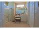 Bathroom featuring a glass-enclosed shower, vanity with a makeup counter, and neutral tile flooring at 13128 Se 97Th Terrace Rd, Summerfield, FL 34491