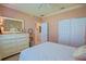 Comfortable bedroom with soft pink walls, closet, dresser and warm carpeting at 13128 Se 97Th Terrace Rd, Summerfield, FL 34491
