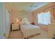 Charming bedroom with soft pink walls, whimsical tree mural, and a cozy, inviting atmosphere at 13128 Se 97Th Terrace Rd, Summerfield, FL 34491