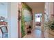 Hallway featuring a large decorative mural, neutral tile floors, and views into the living room and bedroom at 13128 Se 97Th Terrace Rd, Summerfield, FL 34491