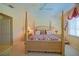 Comfortable bedroom featuring a four-poster bed, complemented by soft carpeting and neutral walls at 13128 Se 97Th Terrace Rd, Summerfield, FL 34491