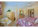 Comfortable bedroom featuring a four-poster bed, complemented by soft carpeting and neutral walls at 13128 Se 97Th Terrace Rd, Summerfield, FL 34491