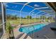 Screened in pool with golf course views on a sunny day at 13128 Se 97Th Terrace Rd, Summerfield, FL 34491