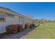 Landscaped side yard with flowering bushes and a glimpse of the golf course at 13128 Se 97Th Terrace Rd, Summerfield, FL 34491