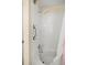 A well-lit shower featuring white tile, a shower head and grab bar at 14059 Sw 47Th Ave, Ocala, FL 34473