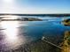Expansive aerial view showcasing the lake with the wooden dock and surrounding lush landscape at 14540 Ne 250Th Ave, Fort Mc Coy, FL 32134