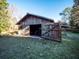 Exterior of a barn with open doors, providing a glimpse into a versatile storage or workspace at 14540 Ne 250Th Ave, Fort Mc Coy, FL 32134