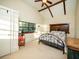 Bedroom featuring a vaulted ceiling with wood beams, a large window, and a decorative metal bed frame at 14540 Ne 250Th Ave, Fort Mc Coy, FL 32134