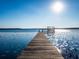 Picturesque wooden dock stretching out into the lake, with sunlight reflecting off the water's surface at 14540 Ne 250Th Ave, Fort Mc Coy, FL 32134
