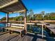 Covered dock featuring a wooden bench and railings, offering a peaceful spot by the lake at 14540 Ne 250Th Ave, Fort Mc Coy, FL 32134