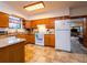 Functional kitchen with oak cabinets, white appliances, and tile flooring; ample counter space and natural light at 14540 Ne 250Th Ave, Fort Mc Coy, FL 32134