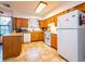 Functional kitchen with oak cabinets, white appliances, and tile flooring; ample counter space and natural light at 14540 Ne 250Th Ave, Fort Mc Coy, FL 32134