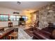 Cozy living room featuring a stone wall, multiple windows, and a comfortable seating area at 14540 Ne 250Th Ave, Fort Mc Coy, FL 32134