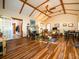 Spacious living room featuring vaulted ceilings, wood beams, a stone fireplace, and hardwood flooring at 14540 Ne 250Th Ave, Fort Mc Coy, FL 32134