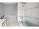 Bathroom featuring tub with tile surround, marble floors, and updated fixtures at 1628 Se 29Th Ter, Ocala, FL 34471