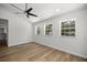 Spacious bedroom with wood-look flooring, ceiling fan, and windows offering serene outdoor views at 1628 Se 29Th Ter, Ocala, FL 34471