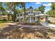 Charming gray two-story home with a turret, front porch, and mature landscaping at 1628 Se 29Th Ter, Ocala, FL 34471
