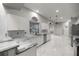 White kitchen with marble flooring, gray countertops and cabinetry, and a arched window at 1628 Se 29Th Ter, Ocala, FL 34471