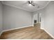 Neutral living room with light wood floors, a fan, and an archway leading to a fireplace at 1628 Se 29Th Ter, Ocala, FL 34471