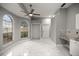 Bright living room with marble floors, arched windows, fan, built in desk, and white front door at 1628 Se 29Th Ter, Ocala, FL 34471