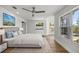 Bright main bedroom with a view of the lake, hardwood floors, a ceiling fan, and abundant natural light at 1628 Se 29Th Ter, Ocala, FL 34471