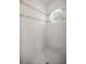 Neutral-tiled shower stall with corner shelves and an oval window for natural light at 1628 Se 29Th Ter, Ocala, FL 34471