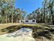 Well-maintained manufactured home with a lush green lawn, mature trees and simple landscaping at 1921 Nw 120Th Ave, Ocala, FL 34482