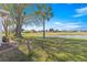 Picturesque backyard featuring mature trees, lush green lawn, and serene water views at 1956 Nw 50Th Cir, Ocala, FL 34482