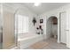 Bathroom featuring a soaking tub, glass-enclosed shower, vanity, toilet, and a decorative window at 1956 Nw 50Th Cir, Ocala, FL 34482